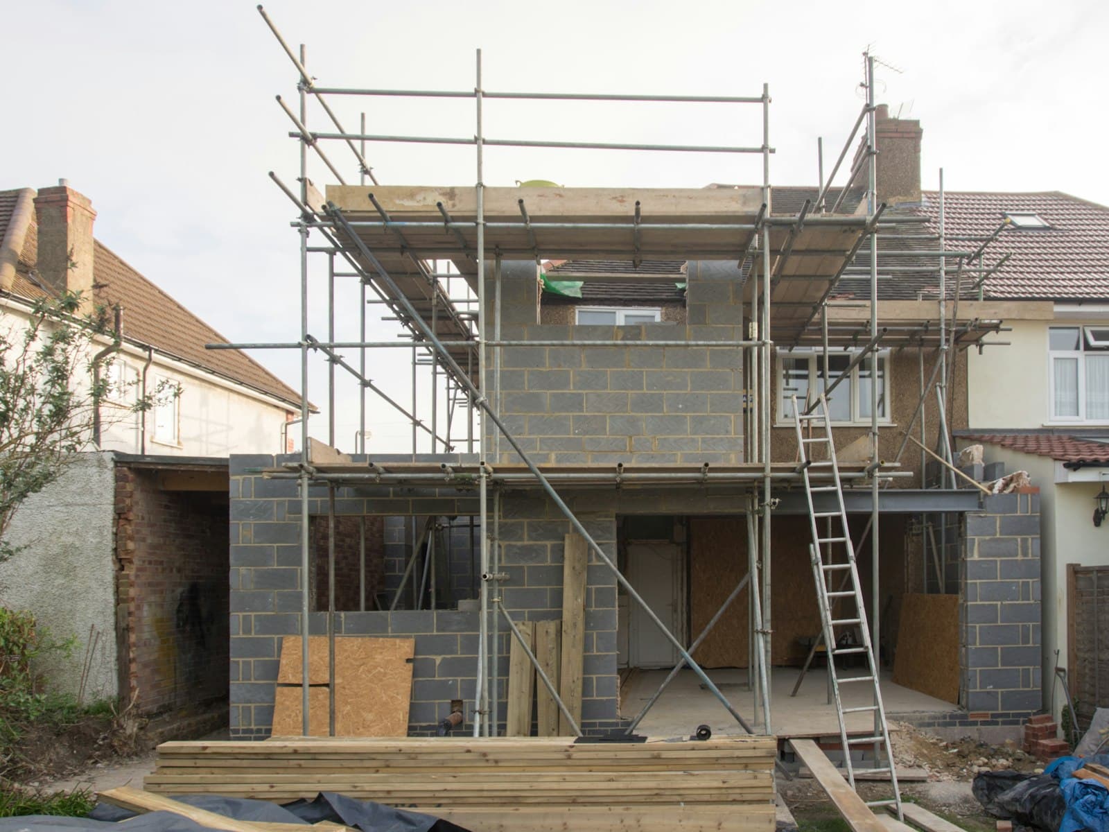 Scaffolding around a two-storey blockwork extension on a British semi-detached house