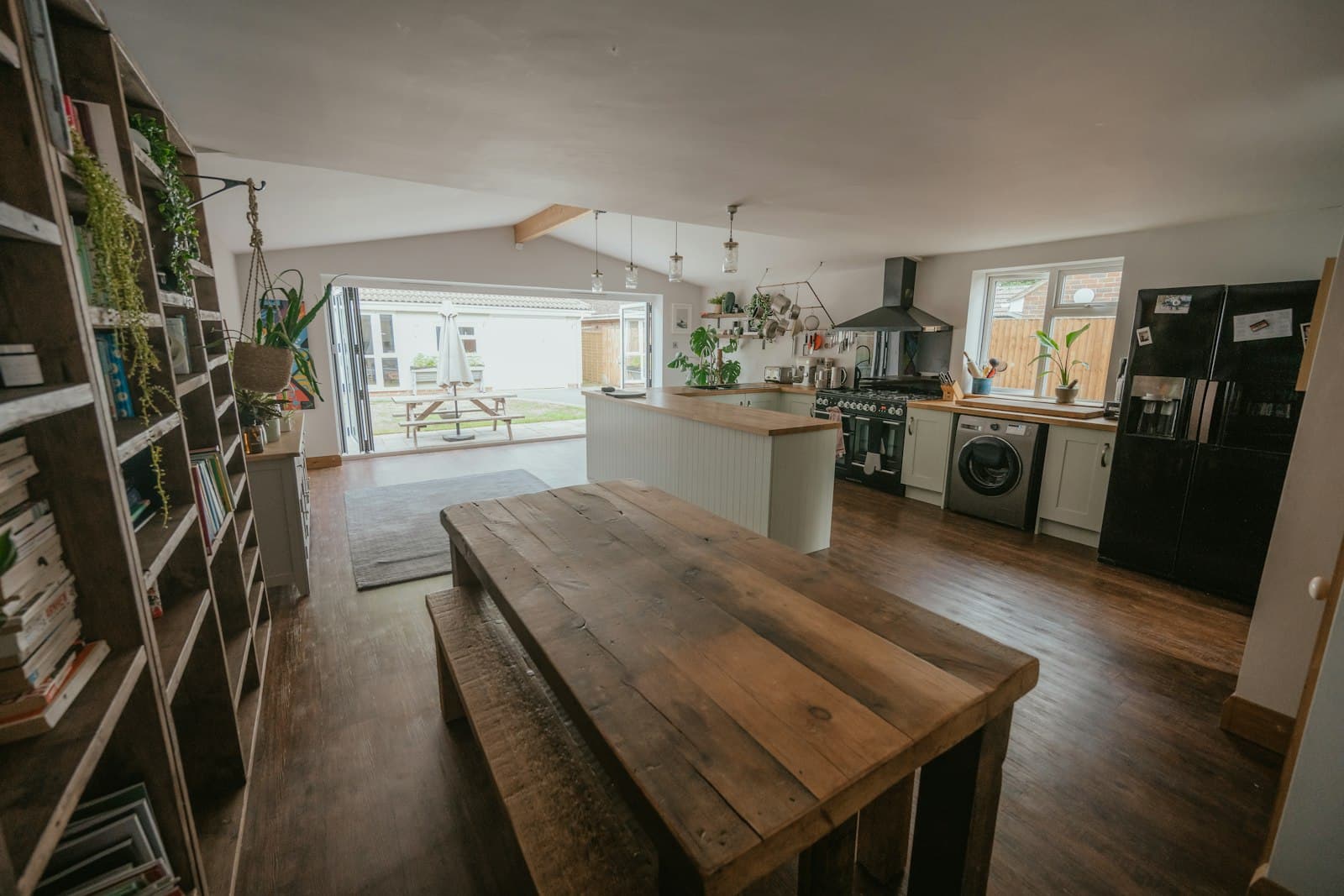 Long kitchen diner with a timber table and open shelving