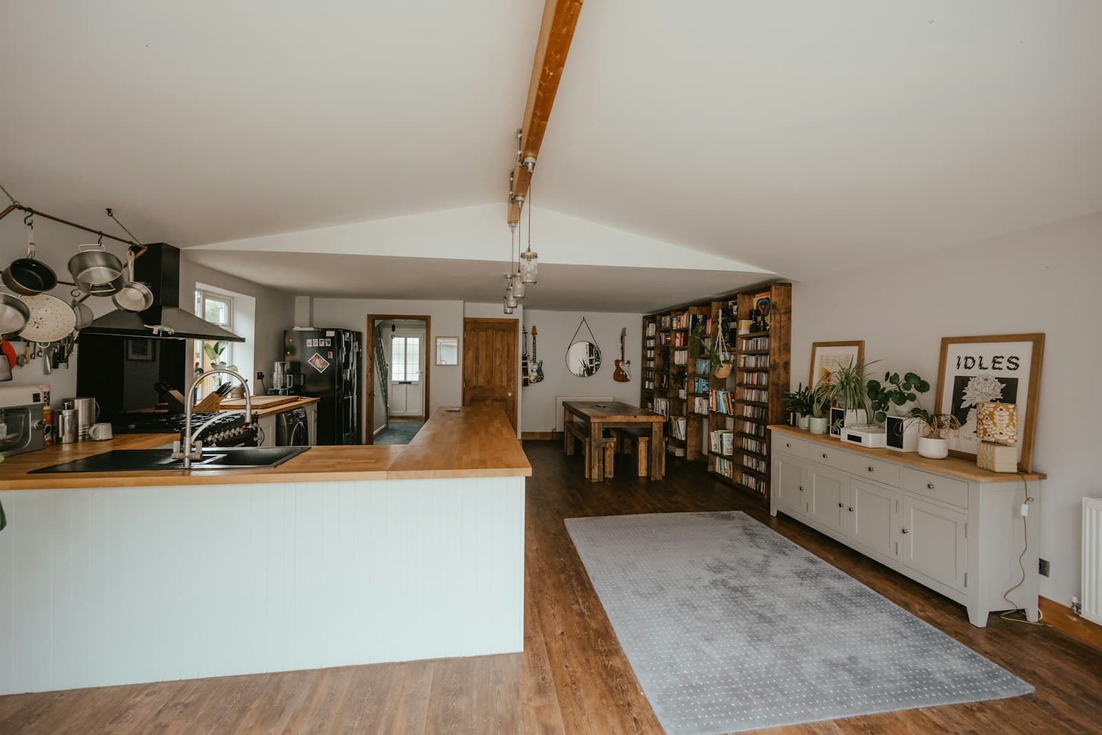 Open-plan kitchen with a vaulted ceiling and exposed beam