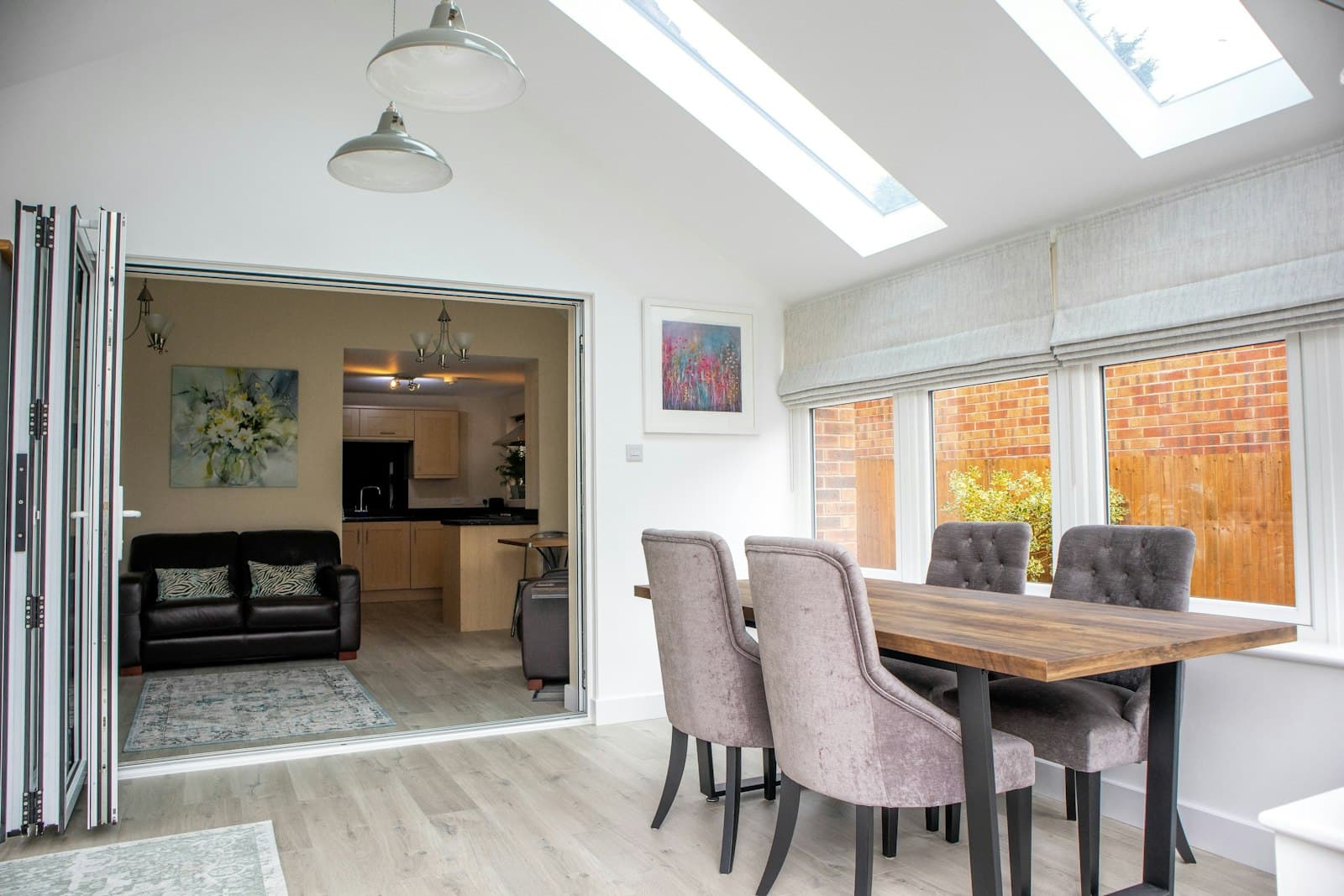 Dining area under roof lights with bifold doors open to the house
