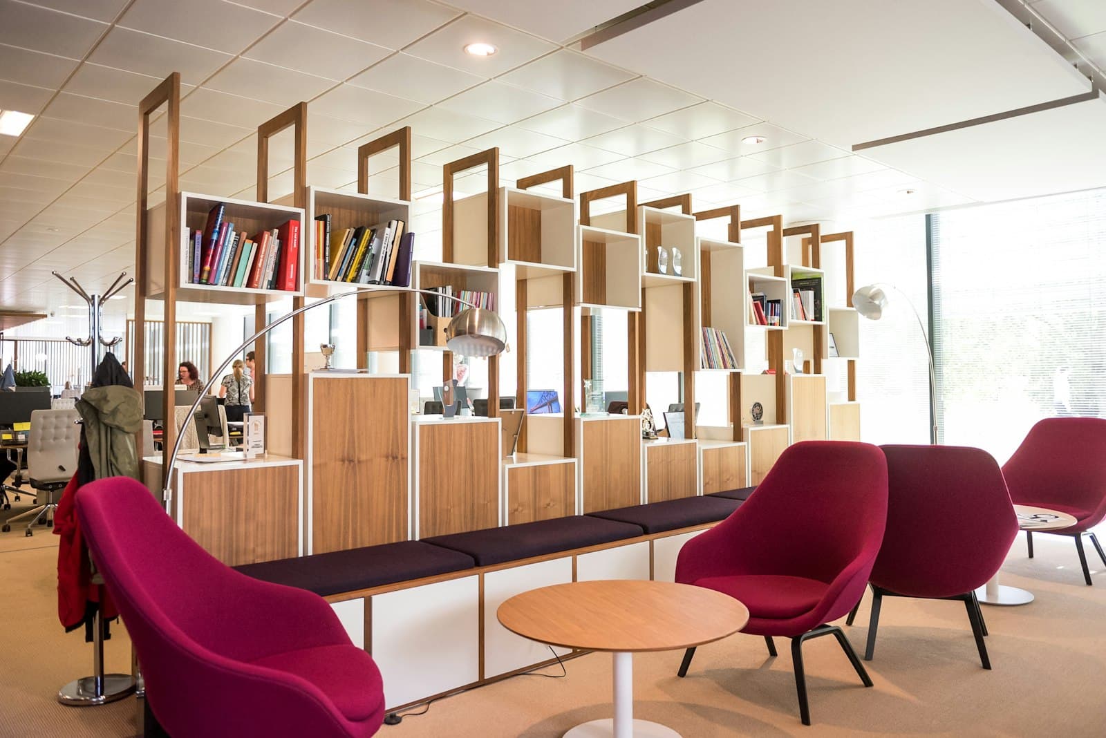 Breakout area with red armchairs and timber shelving
