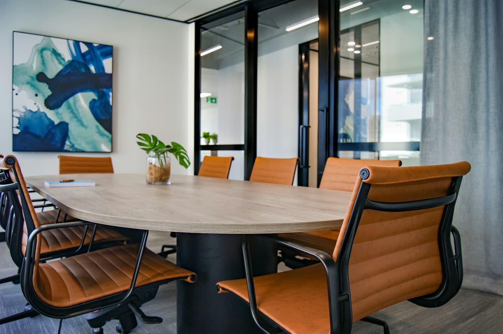 Meeting room with an oval table and tan leather chairs