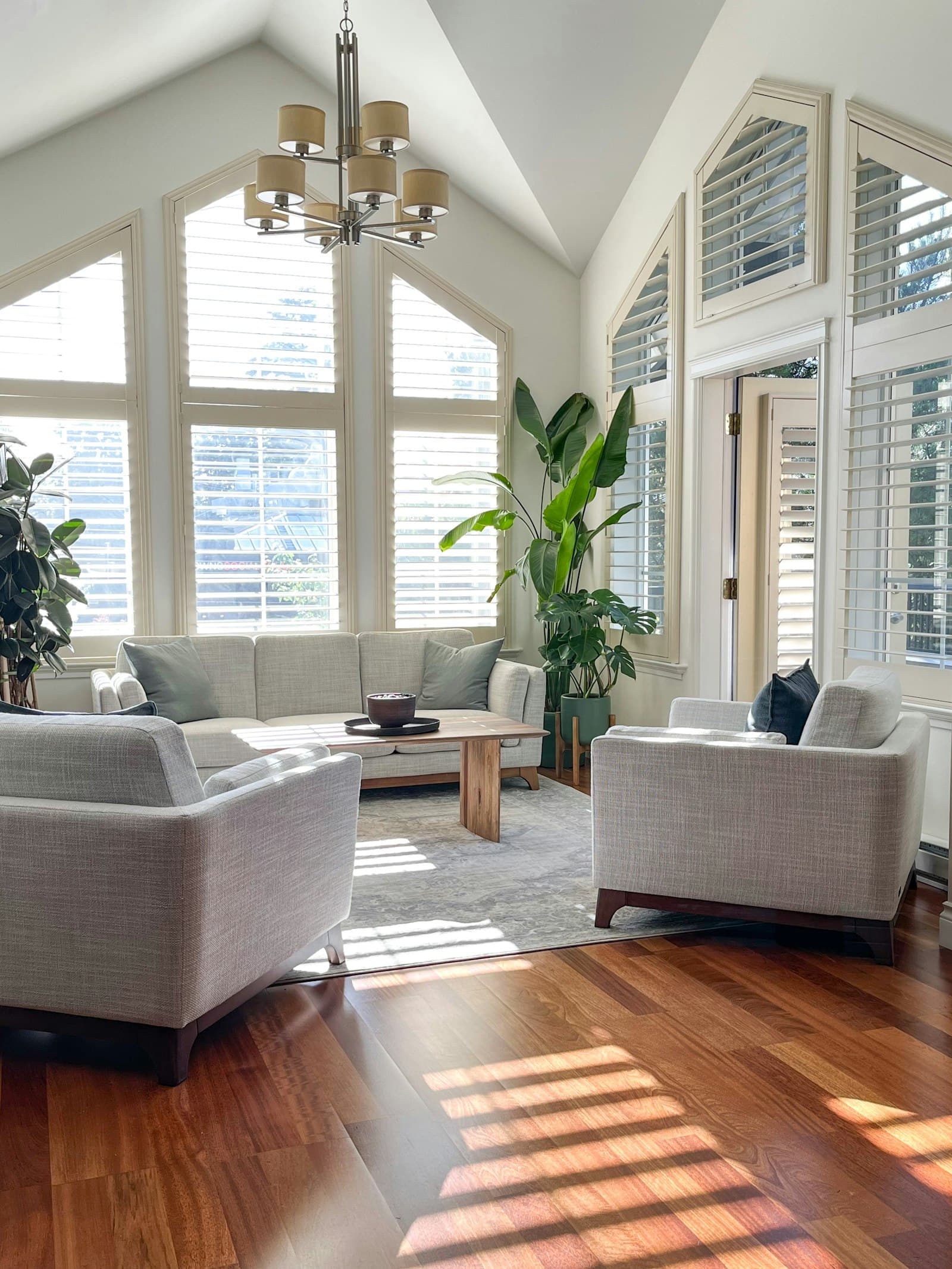 Bright living room with plantation shutters and a vaulted ceiling